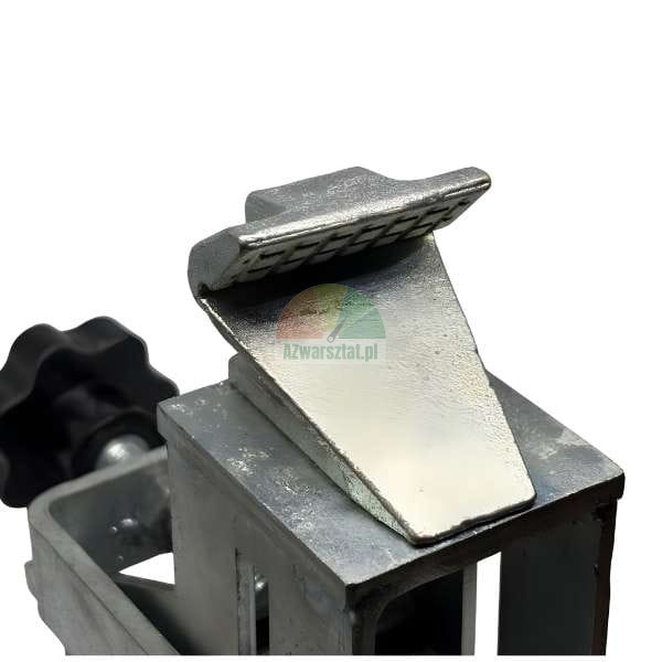 Nahaufnahme eines verzinkten Metallklemmkeils oder Druckwerkzeugteils, montiert auf einem quadratischen Rahmen, mit einem schwarzen Einstellknopf links.
