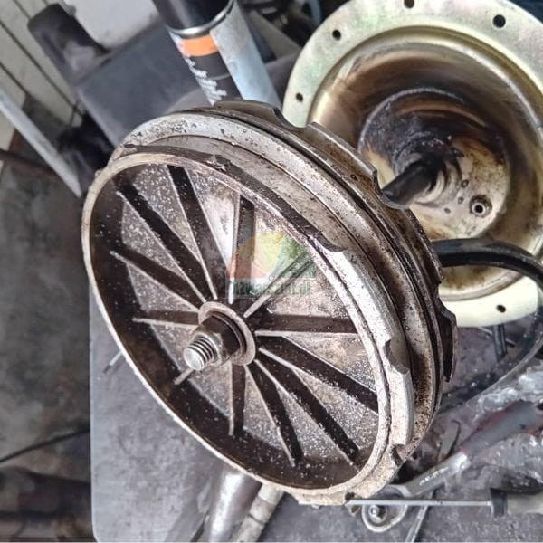 Verschmutztes mechanisches Metallteil mit Rippen und einer Mutter in der Mitte