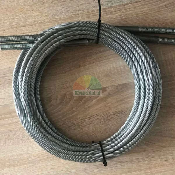 Aufgerolltes Stahlseil mit Gewindeenden auf einer Holzoberfläche