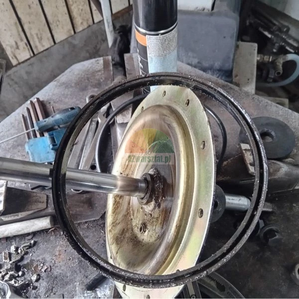 Metallisches Mechanikbauteil mit Welle und Gummidichtung auf einer Werkbank.